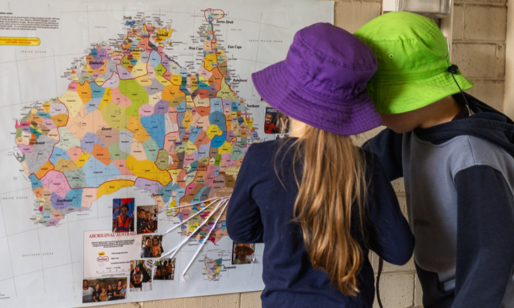 Two primary-school students consult a map of Australia's Aboriginal and Torres Strait Islander Countries.